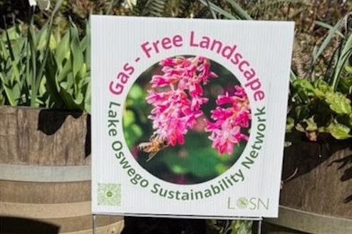 Photo of the "Gas-Free Landscape" LOSN yard sign in front of greenery